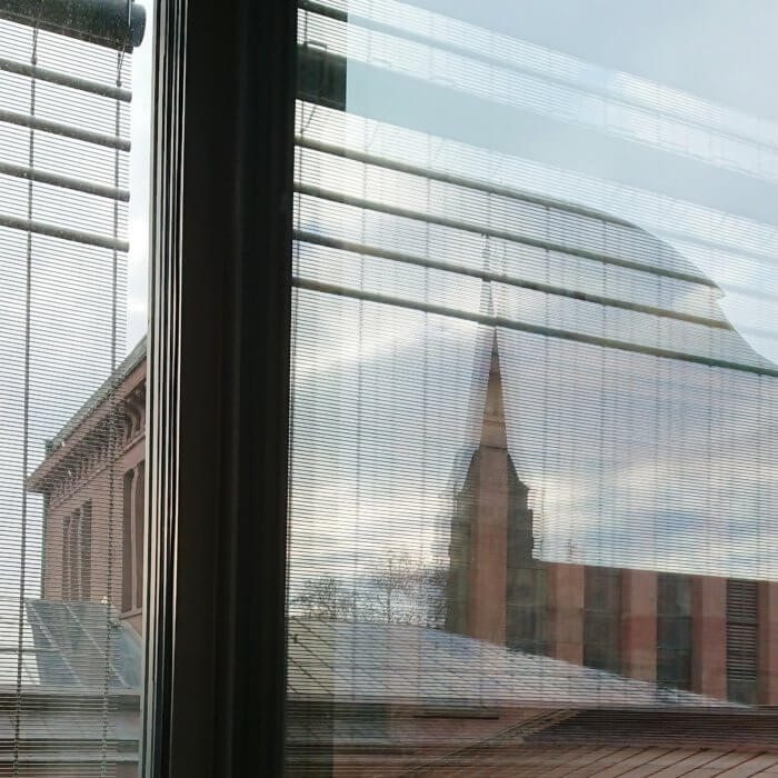 Blick auf die alte Kunsthalle Mannheim, wobei sich die neue Kunsthalle Mannheim im Fenster spiegelt