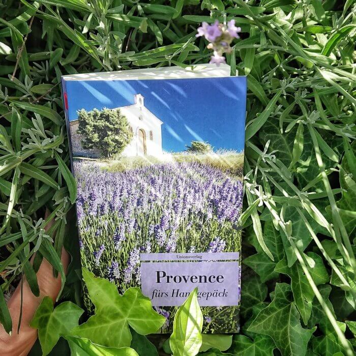 Taschenbuch "Provence fürs Handgepäck". Buch liegt unter einem Lavendelbusch