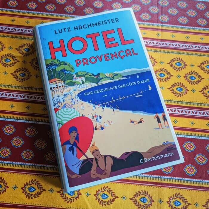 Hôtel Provençal -Eine Geschichte der Côte d'Azur. Das Sachbuch liegt auf einer provenzalischen Tischdecke