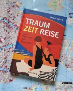 TraumZeitReise.
Eine Geschichte des Tourismus.
Das Buch von Hasso Spode liegt auf einem Stadtplan von Venedig.