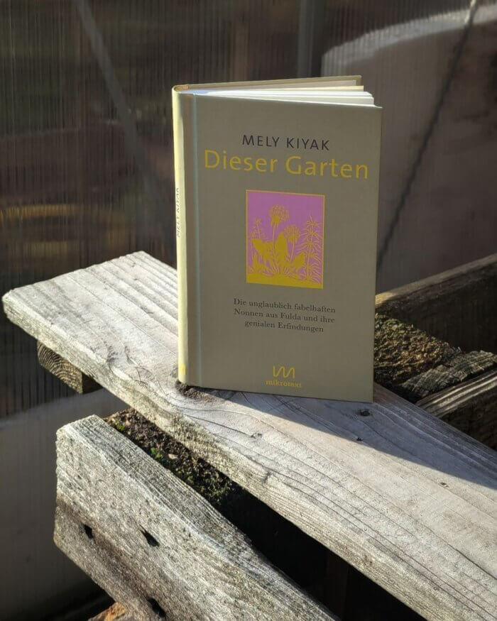 Mely Kiyak
Dieser Garten
Die unglaublich fabelhaften Nonnen aus Fulda und ihre genialen Erfindungen
Das Gartenbuch steht auf dem Rand eines Hochbeets vor einem Gewächshaus