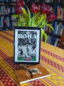 Das Buch Die Roma von MAdeline Potter. Lesesituation mit Tulpen im Hintergrund.
