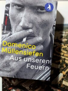 Domenico Müllensiefen - aus unseren Feuern. Das buch liegt auf einem Foto des Leipziger Rundlings, einer Hochhaus-Siedlung